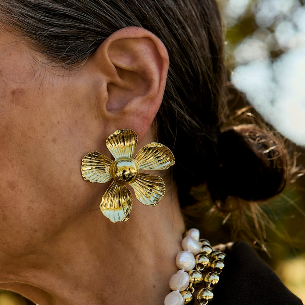 Woman wearing flower shaped gold earrings